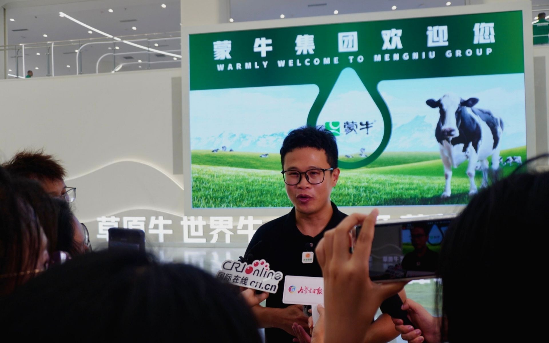 เอกณรงค์ ผู้ก่อตั้ง UnseenChina พูดไมค์ ขณะให้สัมภาษณ์กับสื่อมวลชนจีนภายในโรงงานของเหมิ่งหนิว