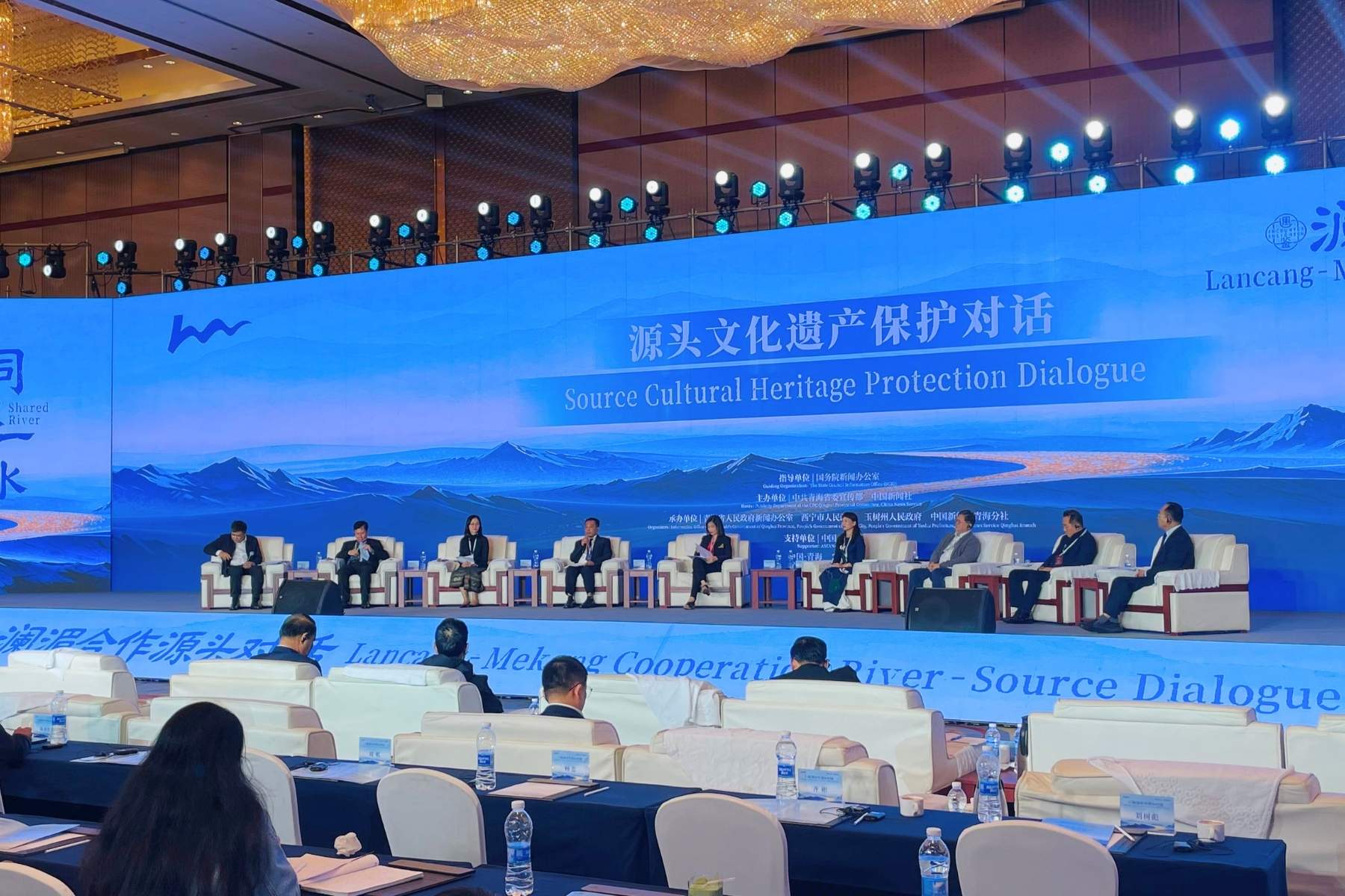 Representatives from six Lancang-Mekong countries seated and delivering speeches on stage during the Source Cultural Protection Heritage Dialogue, with a blue event backdrop.